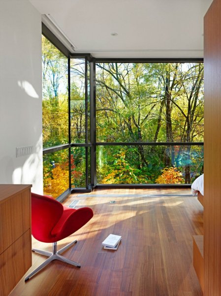 Red-Chair-Overlooking-Green-Outside-View-Through-Glass-Wall